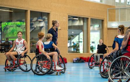 Jongeren in een rolstoel spelen basketbalwedstrijd tijdens de clinic