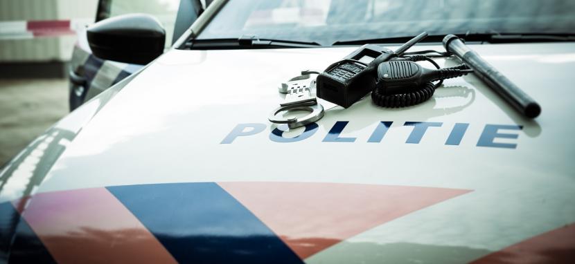 De voorkant van een politieauto met handboeien en een wapenstok