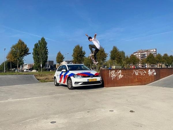 Skateboarder springt over politieauto