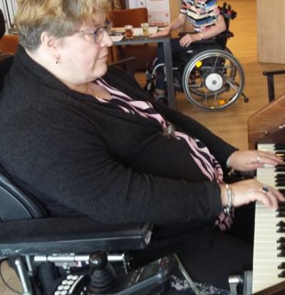 Op de foto Wilma Groeneveld in haar rolstoel achter het orgel.